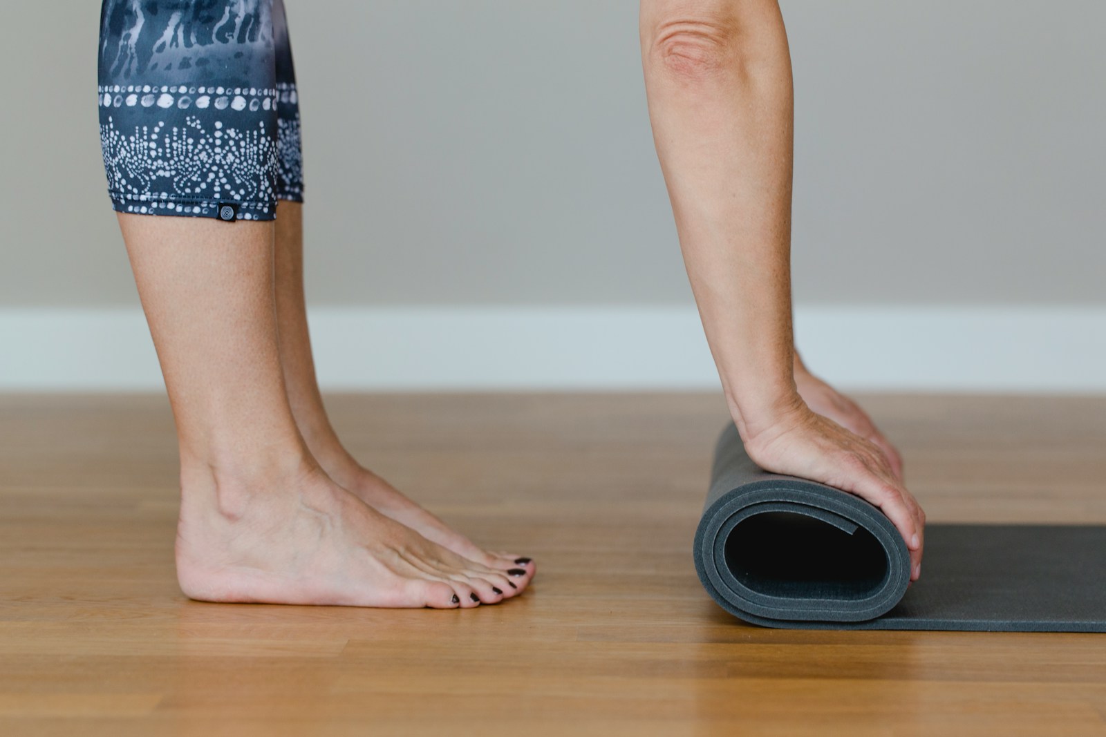 A woman standing on a yoga mat with her feet on the mat